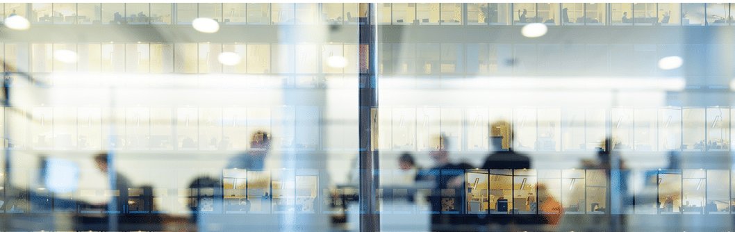 Workers working late. Tall building reflected